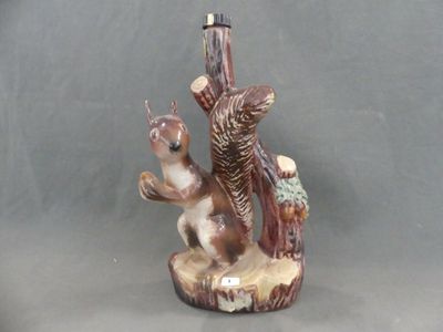 une figurine représentant un écureuil et un écureuil perché sur une souche d'arbre