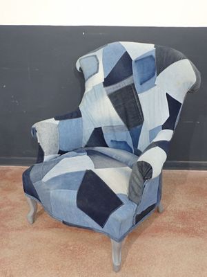 a blue and white patchwork chair with a black and white blanket on it