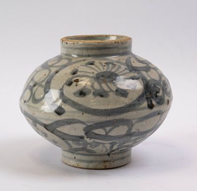 un vase bleu et blanc posé sur une surface blanche