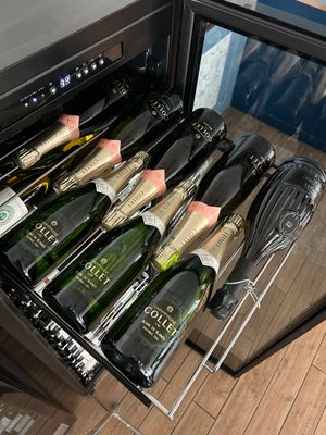 Les bouteilles de champagne se trouvent dans une cave à vin où sont rangés des accessoires