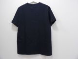 a black t - shirt hanging on a hanger against a white wall
