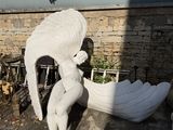 a statue of a woman holding a bird next to a boat