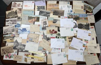 de nombreuses cartes postales anciennes posées sur une table, avec une chaise en arrière-plan