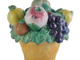 une figurine en céramique représentant un panier de fruits et légumes