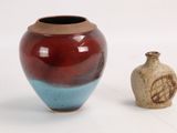 deux vases posés l'un à côté de l'autre sur une surface blanche