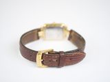 an image of a brown leather watch band with a gold buckle