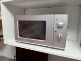 a microwave sitting on top of a shelf in a kitchen