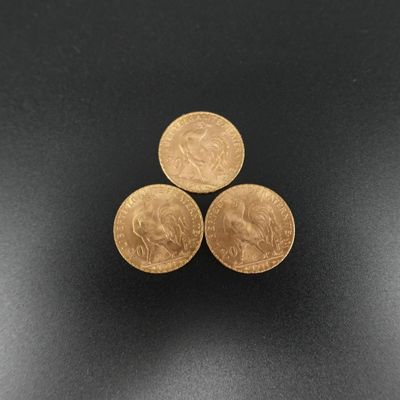 trois pièces d'or empilées les unes sur les autres sur une surface noire