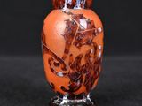 an orange vase with a picture of a horse on it