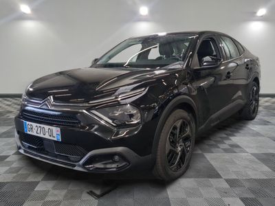 la voiture noire est garée sur un sol en damier dans le garage
