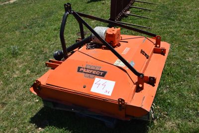 an orange lawn mower that is sitting in the grass