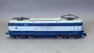 un train bleu et blanc sur les rails, sur un fond gris