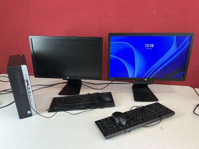 trois écrans d'ordinateur et un clavier posés sur un bureau