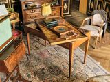 un salon avec une table, une chaise et d'autres meubles