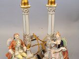 pair of porcelain figurines of a man and a woman sitting on a chair