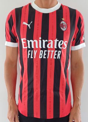 Le jeune homme porte un t-shirt rayé rouge et noir.