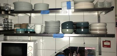 beaucoup d'assiettes et de bols sur les étagères de la cuisine