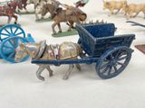 many figurines of horses pulling a wagon with a man on it
