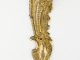brass wall sconce with a bird on the back of it