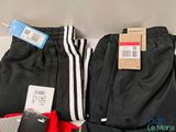 two pairs of black and white pants and a red bag