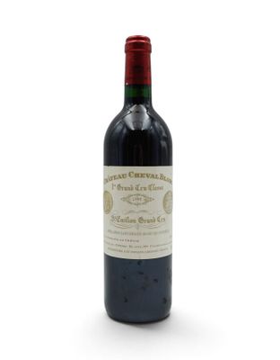 a bottle of red wine sitting on top of a white table