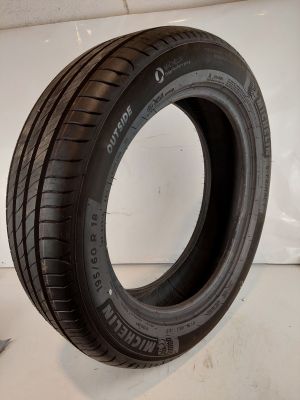 un gros plan d'un pneu posé sur une surface blanche, à côté d'une paire de ciseaux