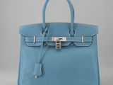 un sac à main en cuir bleu muni d'un fermoir métallique sur la poignée