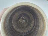 a person holding a cup that has a brown liquid inside of it