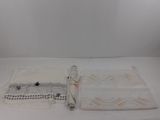 two white towels and a black and white towel on a white surface