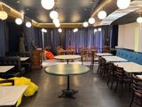 many tables and chairs in a room with blue and yellow chairs