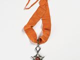 an orange ribbon with a silver star and a red rose on it