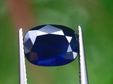 un gros plan d'un diamant bleu tenu par une pince