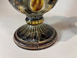 a silver vase that has a picture of a woman on it