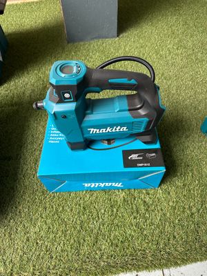 a small blue machine that is sitting on a green carpet