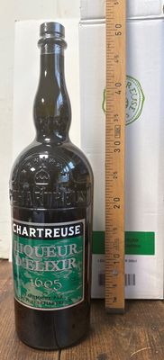 une bouteille d'alcool posée sur une table à côté d'une règle