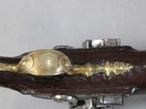 a close up of a brass plated gun on a white surface