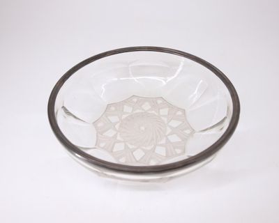 un bol en verre orné d'un motif, posé sur une surface blanche