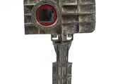 a small metal object with a red eye on top of it