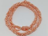 a close up of a beaded necklace on a white surface