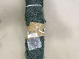 un rouleau de fil vert enroulé dans du fil métallique, posé sur une table