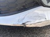a close up of a car ' s front bumper with a denting on it