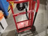 a red hand truck that is sitting in a warehouse