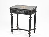 a black and gold painted table with a drawer on top of it