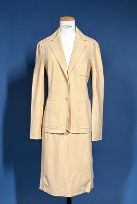 an image of a woman ' s tan suit on a mannequin stand