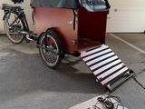 un vélo auquel est attelée une remorque, dans un parking