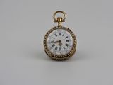 une montre de poche ancienne en or avec des chiffres romains sur le cadran