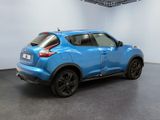 the rear end of a blue nissan juke suv parked in a showroom