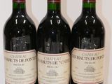 three bottles of red wine are lined up on a white surface