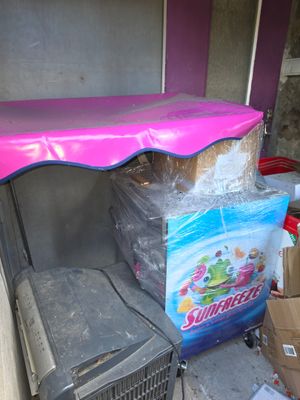 a pink umbrella on top of a refrigerator next to boxes