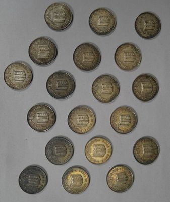 several coins are arranged in a circle on a white surface